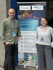 A. Sommer und C. Seiwerth vor Plakat zur rKonferenz